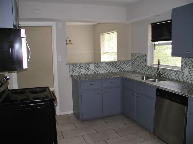 a kitchen with a sink stove and cabinets