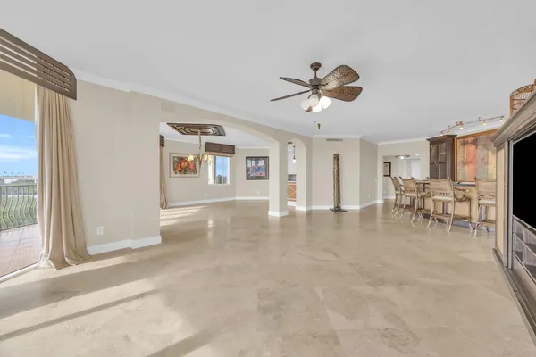 a dining hall with stainless steel appliances kitchen island granite countertop a table chairs and a refrigerator