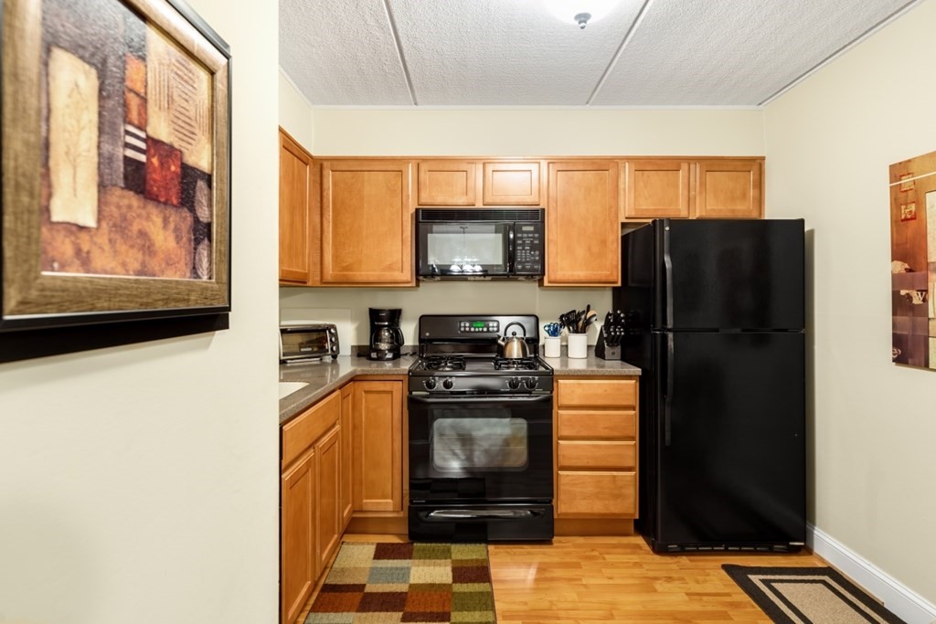 1500 Worcester Road, Unit 321 Framingham, MA 01702 - Photo 17 of 42 a kitchen with a refrigerator and a stove