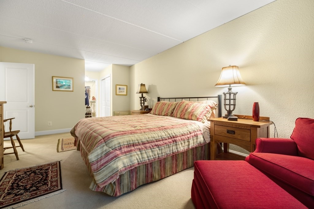 1500 Worcester Road, Unit 321 Framingham, MA 01702 - Photo 21 of 42 a bedroom with a bed and wooden floor