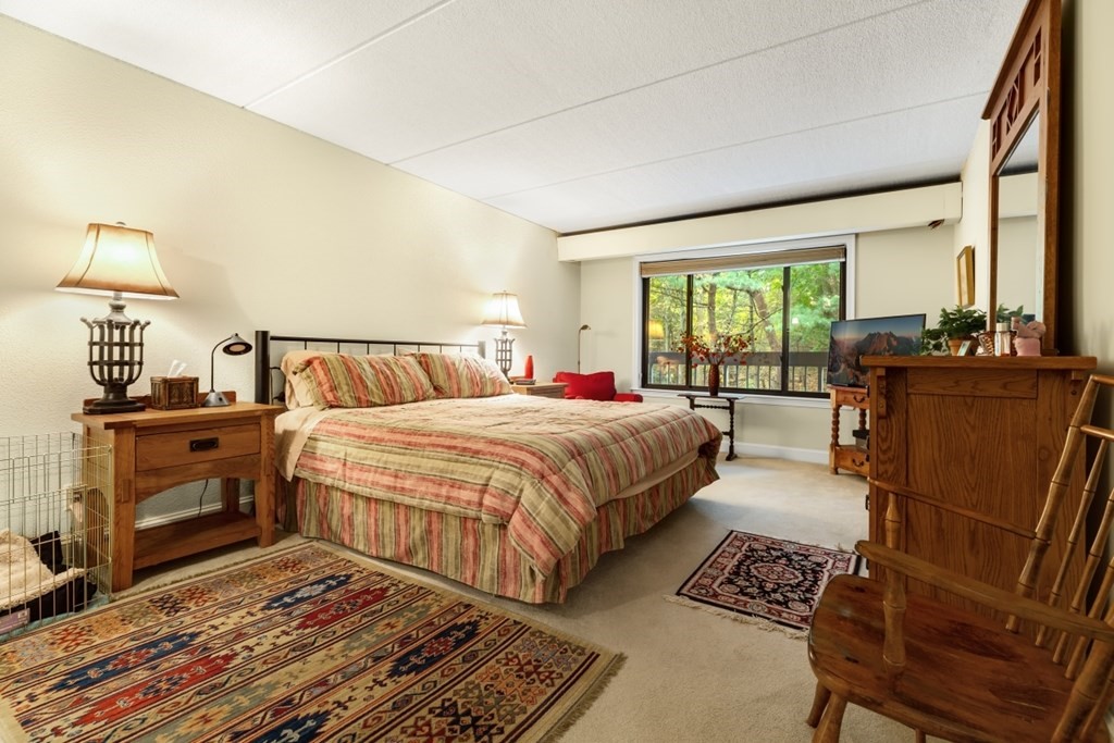 1500 Worcester Road, Unit 321 Framingham, MA 01702 - Photo 22 of 42 a bedroom with a bed and wooden floor