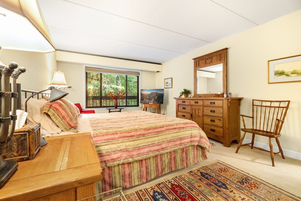 1500 Worcester Road, Unit 321 Framingham, MA 01702 - Photo 23 of 42 a bedroom with a bed a dresser and chair