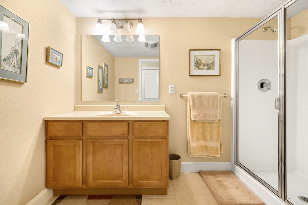1500 Worcester Road, Unit 321 Framingham, MA 01702 - Photo 25 of 42 a bathroom with a sink a mirror and a shower