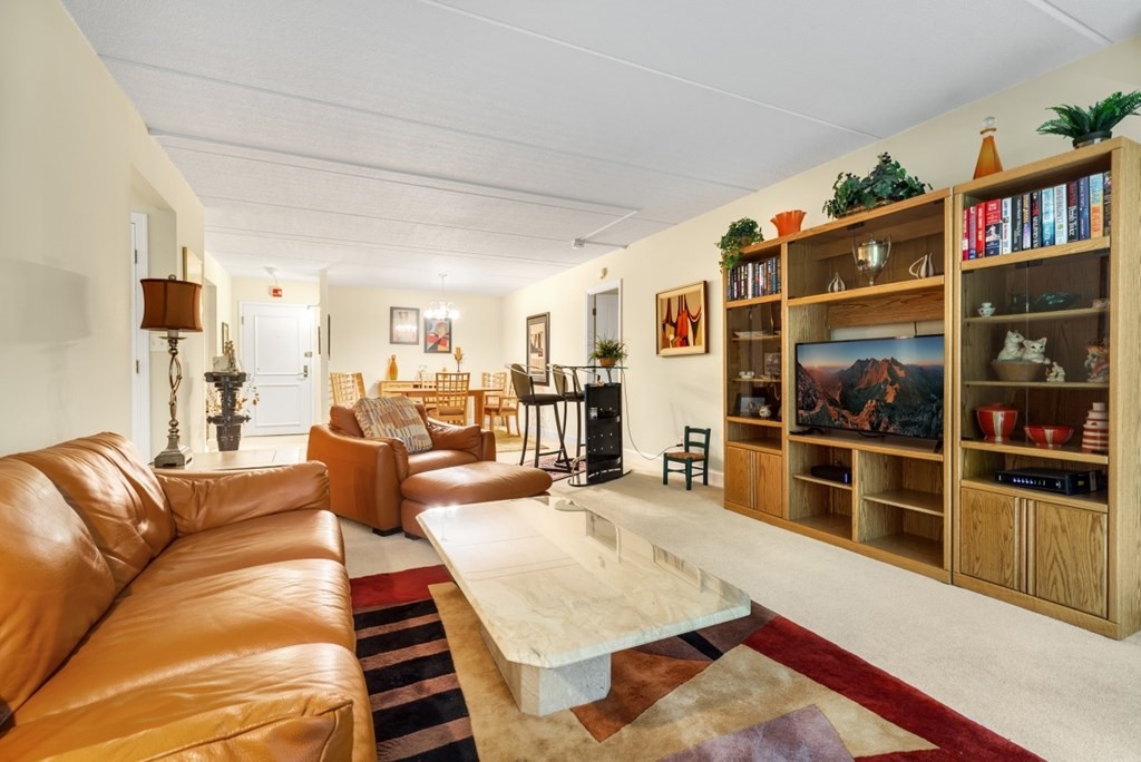 1500 Worcester Road, Unit 321 Framingham, MA 01702 - Photo 7 of 42 a living room with furniture and a book shelf