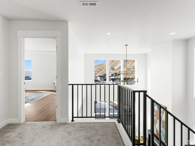 1711 West Canyon Rim Road North Lehi, UT 84048 - Photo 18 of 31 Upper-level landing featuring a black metal balustrade, recessed lighting, and a modern chandelier