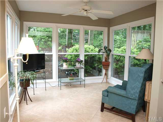 Sun Room has new porcelain tile floors and 7 windows overlooking wooded back yard