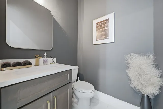 a bathroom with a sink vanity mirror and toilet