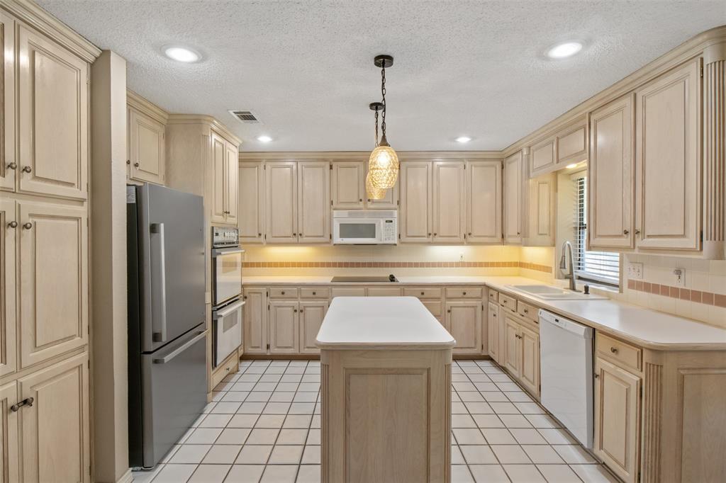 8919 Bontura Road Granbury, TX 76049 - Photo 15 of 35 a kitchen with a sink refrigerator and cabinets
