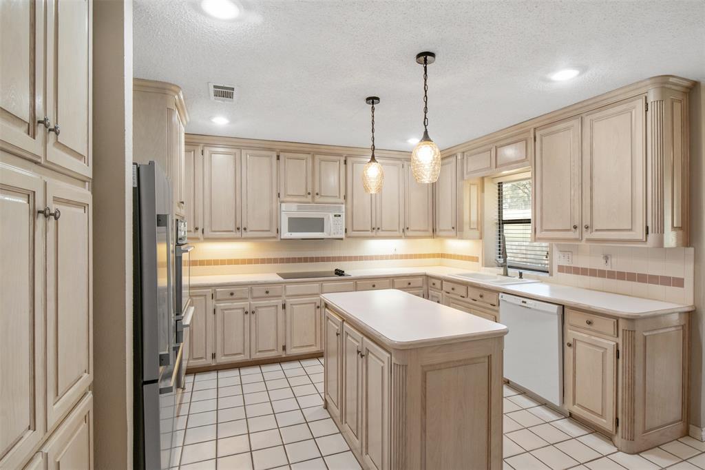 8919 Bontura Road Granbury, TX 76049 - Photo 17 of 35 a kitchen with a sink stove and cabinets