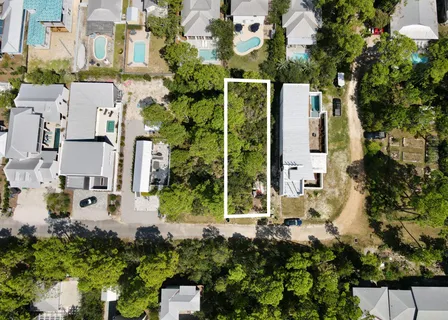 an aerial view of residential houses with outdoor space and trees