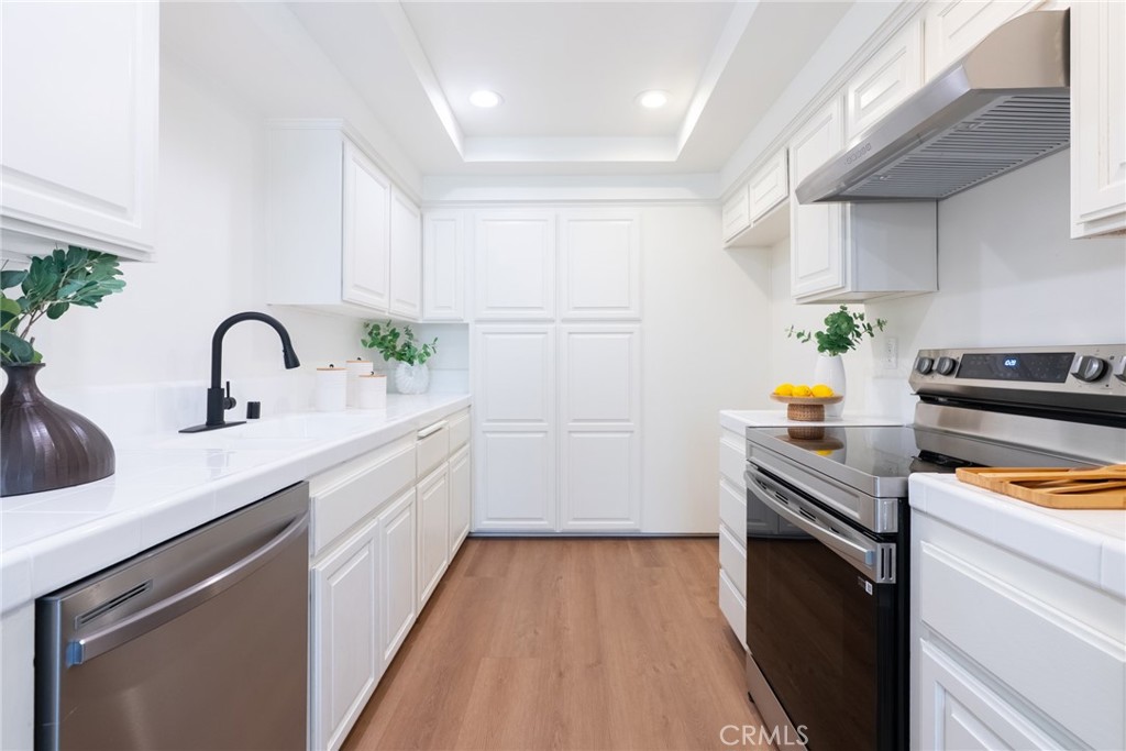 1024 West Lamark Lane Anaheim, CA 92802 - Photo 7 of 34 a kitchen with a sink white cabinets a counter space and a window