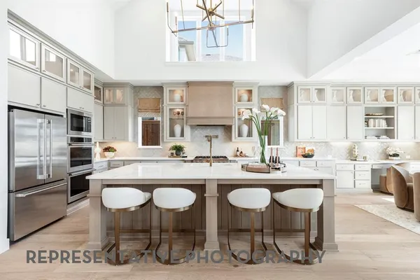 a kitchen with stainless steel appliances granite countertop a sink and a refrigerator