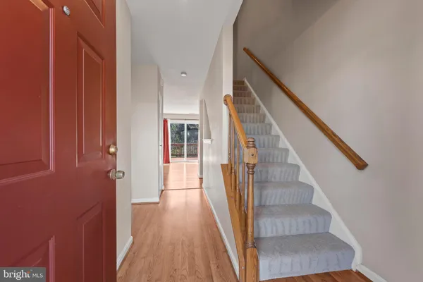 a view of staircase with wooden floor and white walls