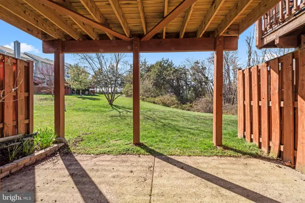 a view of a backyard with wooden floor and wooden fence