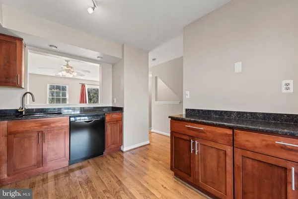 a kitchen with granite countertop a sink cabinets and stainless steel appliances