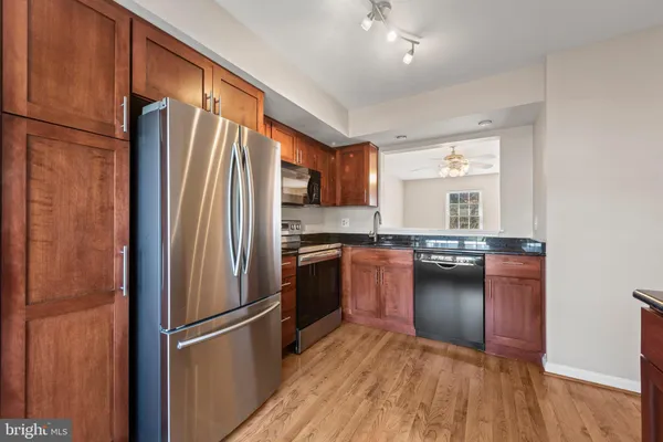 a kitchen with a refrigerator a stove and a wooden floor