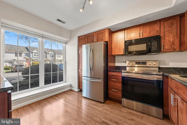 a kitchen with stainless steel appliances granite countertop a refrigerator microwave and stove top oven
