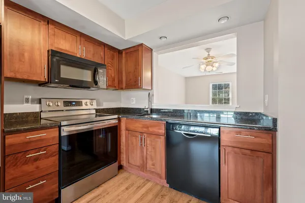 a kitchen with stainless steel appliances granite countertop a stove microwave and sink