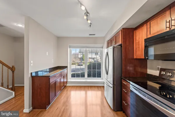 a kitchen with stainless steel appliances granite countertop a refrigerator and a stove top oven