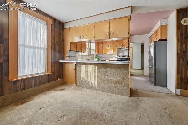 a view of a kitchen with stainless steel appliances granite countertop cabinets and a window
