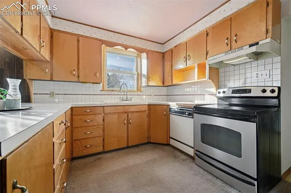a kitchen with granite countertop a stove sink and cabinets