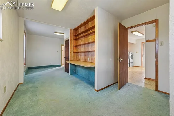 an empty room with closet and windows