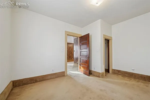 an empty room with closet and mirror