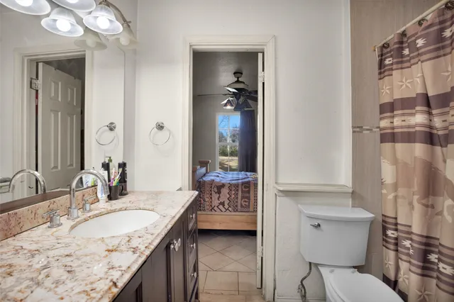 a bathroom with a granite countertop sink mirror vanity and toilet