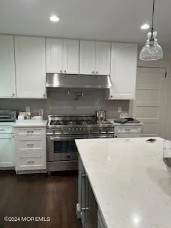 a kitchen with granite countertop a stove and a sink