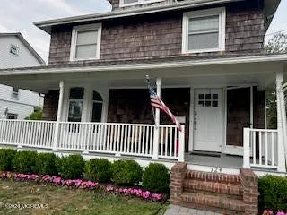 a view of a house in front of a yard with flower plants