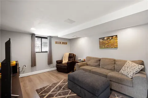 a living room with furniture a flat screen tv and a window