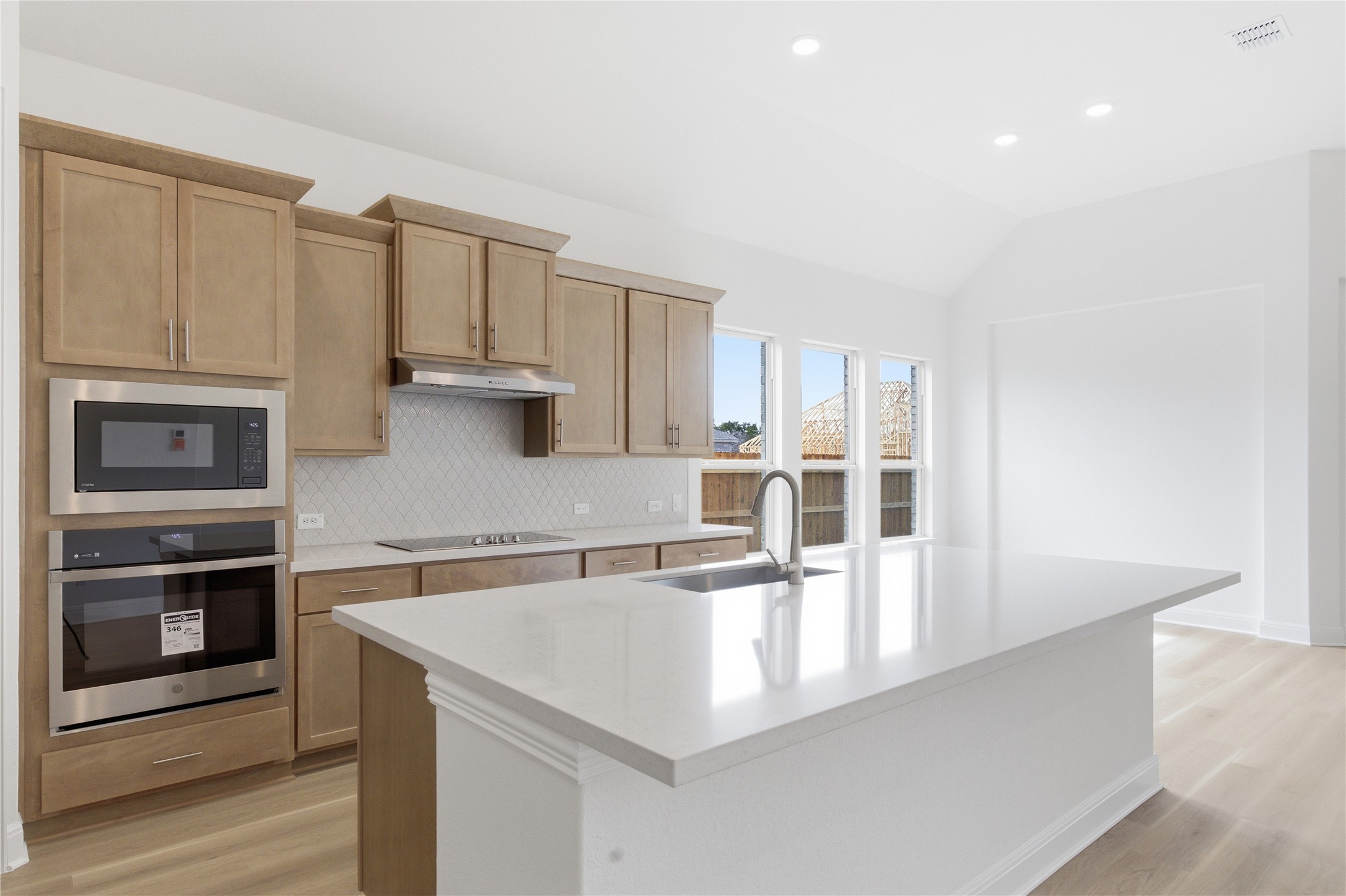101 Lost Treasure Terrace Georgetown, TX 78628 - Photo 5 of 32 a kitchen with stainless steel appliances granite countertop a refrigerator a stove and white cabinets with wooden floor
