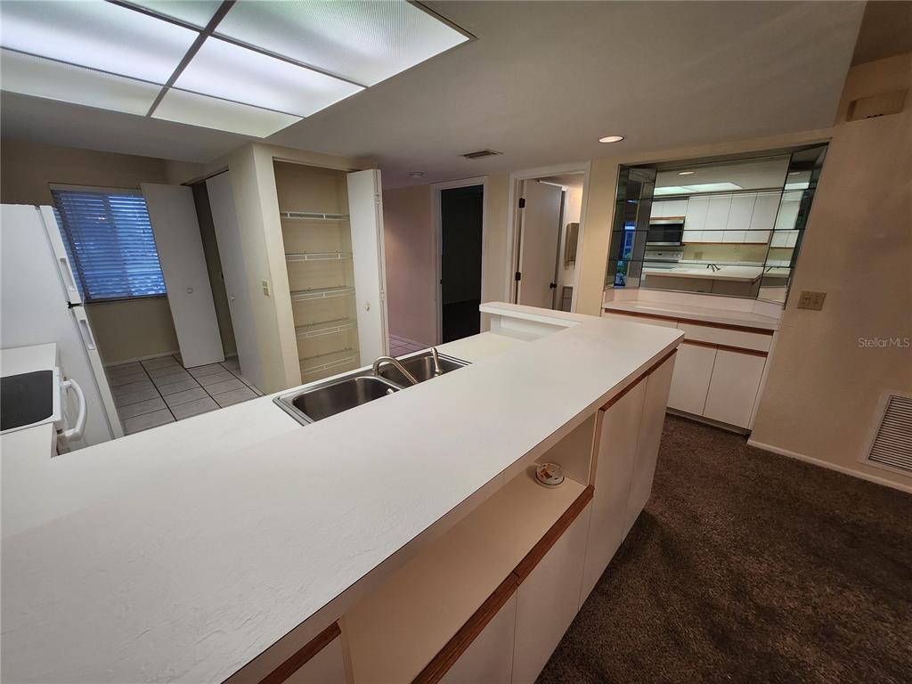 6800 Placida Road, Unit 1004 Englewood, FL 34224 - Photo 4 of 26 a kitchen with stainless steel appliances kitchen island sink refrigerator and stove