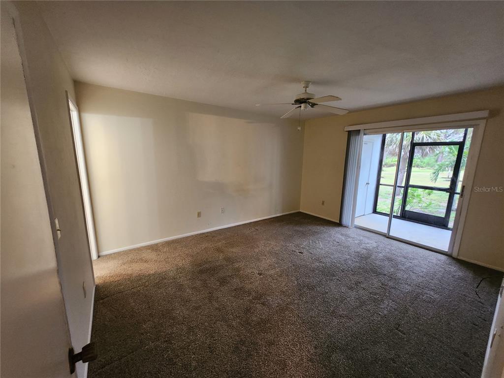 6800 Placida Road, Unit 1004 Englewood, FL 34224 - Photo 8 of 26 an empty room with windows and a ceiling fan