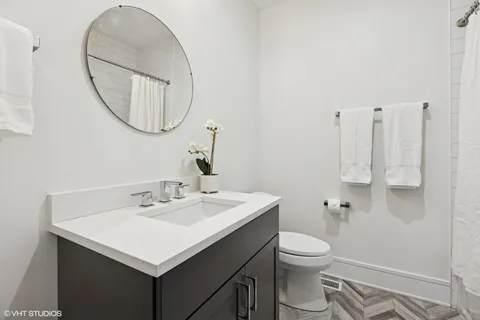 a bathroom with a sink a toilet and a mirror