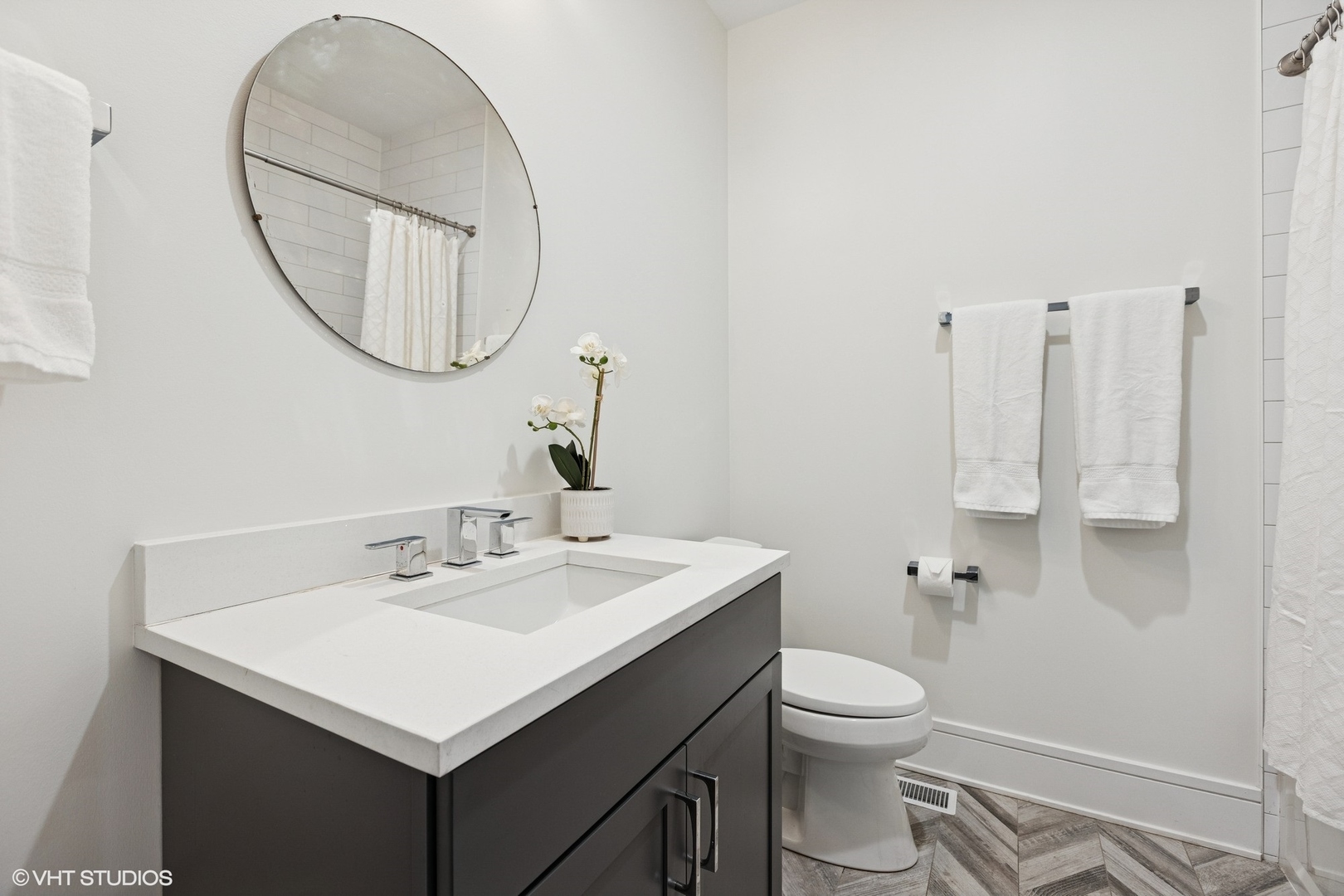 5748 North Hermitage Avenue, Unit 102 Chicago, IL 60660 - Photo 16 of 34 a bathroom with a sink a toilet and a mirror
