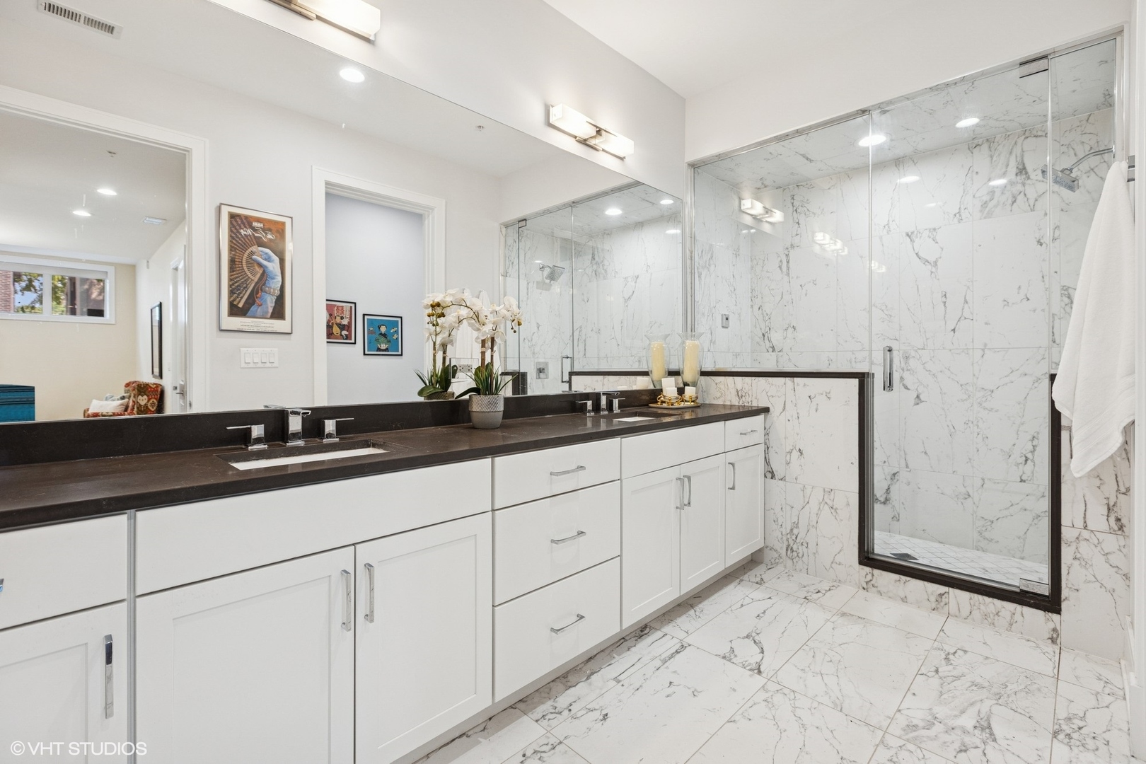 5748 North Hermitage Avenue, Unit 102 Chicago, IL 60660 - Photo 26 of 34 a large bathroom with a double vanity sink a large mirror a shower and a