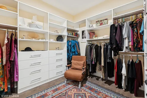 a view of walk in closet with clothes and shoes