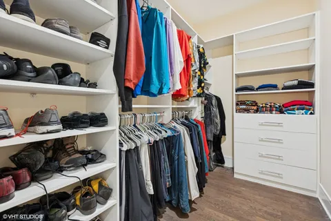 a view of walk in closet with clothes and shoes