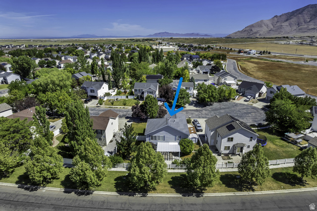 546 Wheatridge Road Tooele, UT 84074 - Photo 47 of 49 Residential property in a neighborhood setting with established trees and surrounding mountainous terrain (blue arrow)