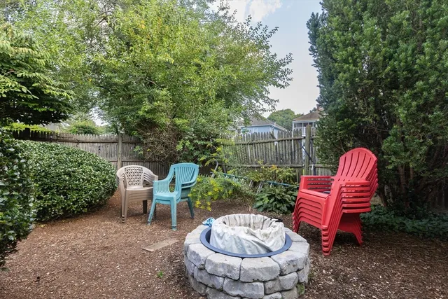 a view of a backyard with table and chairs couches and a fire pit