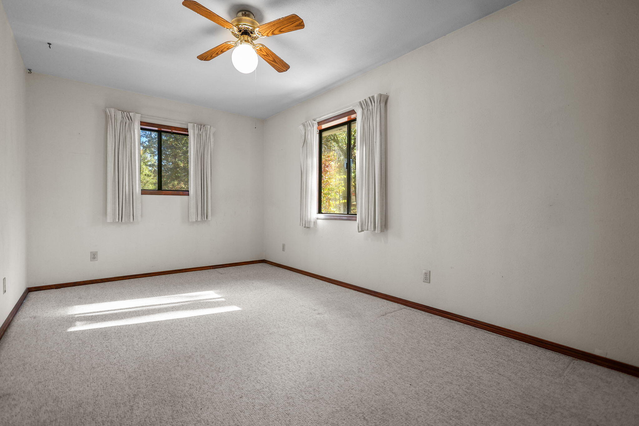 28424 Alpine Way Shingletown, CA 96088 - Photo 21 of 42 an empty room with windows and fan