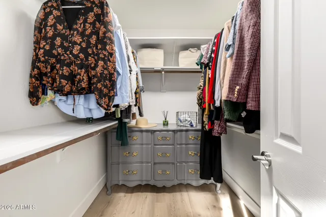 a view of walk in closet with clothes and shoes