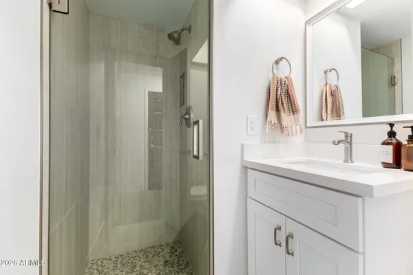 a bathroom with a shower sink and mirror