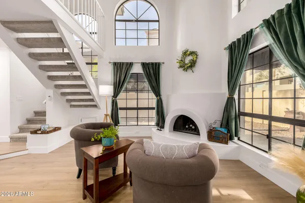 a living room with furniture a fireplace and a floor to ceiling window