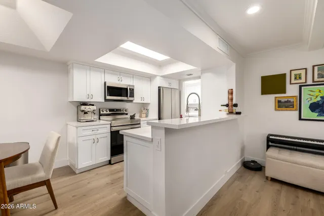 a kitchen with white cabinets and appliances