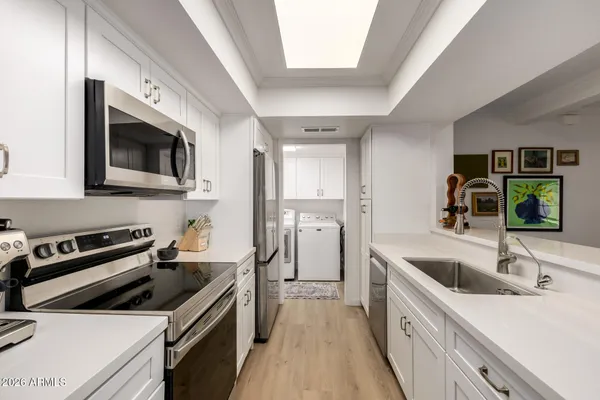 a kitchen with granite countertop a sink and steel appliances