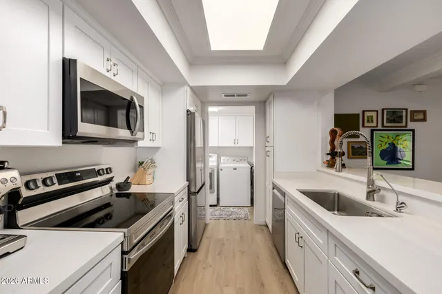 a kitchen with granite countertop a sink and steel appliances
