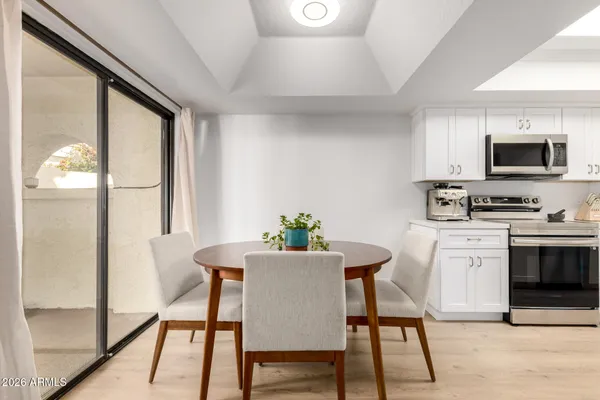 a kitchen with a table chairs refrigerator and microwave
