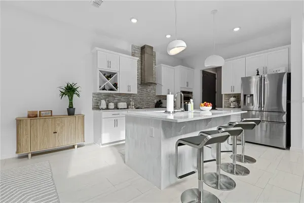 a kitchen with refrigerator and chairs